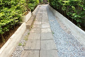 Takeoff Monkey blog hardscape sample image: stone paver pathway with pebble rocks and garden beds
